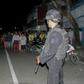Officers stand guard after the explosion at the home of a suspected militant on Sumatra island