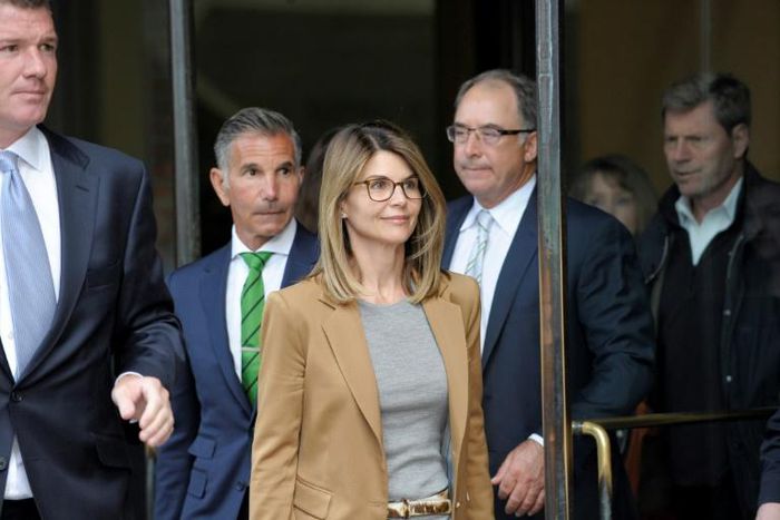 "Full House" star Lori Loughlin (C) and her husband, designer Mossimo Giannulli (L), were among 50 people indicted in the wide-ranging college bribery scandal