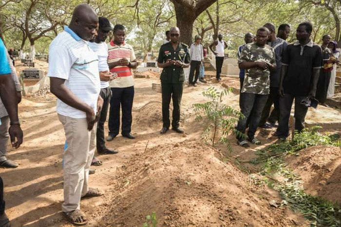 Mourners stand beside the grave of slain Ghanaian investigative journalist Ahmed Husein Suale who was gunned down in January as he returned to his home in Accra
