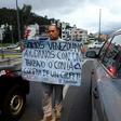 A Venezuelan living in Ecuador -- one of the millions from his country who have fled an economic meltdown -- holds a sign asking for a job or for people to buy one of his lollipops, on a street corner in Quito, Ecuador, in January 2019