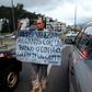 A Venezuelan living in Ecuador -- one of the millions from his country who have fled an economic meltdown -- holds a sign asking for a job or for people to buy one of his lollipops, on a street corner in Quito, Ecuador, in January 2019
