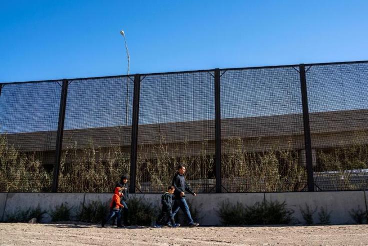 A family from El Salvador is pictured walking to turn themselves into Border Patrol agents after crossing the Rio Grande to claim asylum in El Paso, Texas