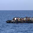 Migrants wait to be rescued by Italian coast guard in the Mediterranean Sea, nautical miles from the Libyan coast, on August 6, 2017