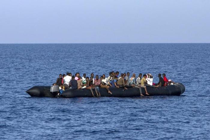 Migrants wait to be rescued by Italian coast guard in the Mediterranean Sea, nautical miles from the Libyan coast, on August 6, 2017