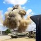 Smoke rising from an air strike behind vehicles belonging to forces loyal to Libya's unity government, in the suburb of Wadi Rabie south of the capital Tripoli on Friday