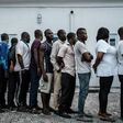 Suspects who were arrested by Nigerian Army personnel on election day in connection with various alleged electoral offenses, including stealing a carton of presidential ballot papers, stand in line to be handed over to police in Port Harcourt