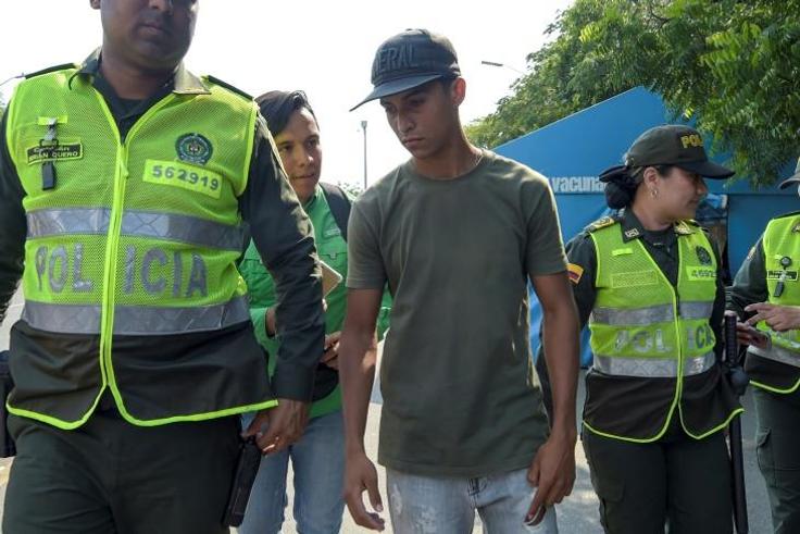 Colombian police officers escort a member of Venezuela's armed forces (C) who deserted to Colombia, in Cucuta, on February 25, 2019 -- Colombian officials say 326 soldiers have deserted so far
