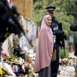 Members of the Muslim community take pictures with armed police outside the Al Noor mosque in Christchurch