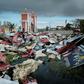People collect metal sheets from a damaged supermarket to rebuild their houses destroyed by Cyclone Idai in Beira, Mozambique