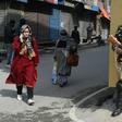 An Indian paramilitary trooper stands guard in front of closed shops in Srinagar in March