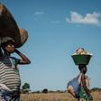 A 32-year-old pregnant woman heads home after collecting maize from flooded ground