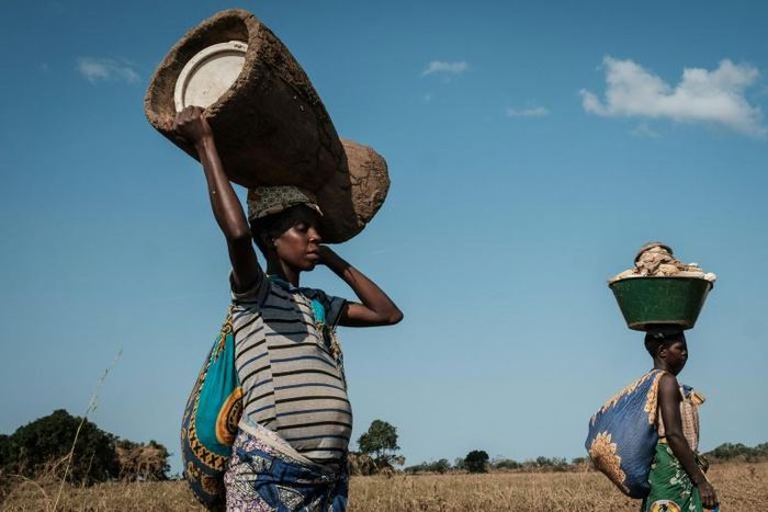 A 32-year-old pregnant woman heads home after collecting maize from flooded ground