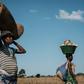 A 32-year-old pregnant woman heads home after collecting maize from flooded ground
