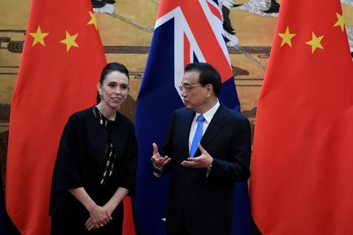 New Zealand Prime Minister Jacinda Ardern listens to Chinese Premier Li Keqiang during a signing ceremony after their meeting at the Great Hall of the People in Beijing on Monday