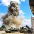 Smoke rises from an air strike behind a tank and pickup trucks of forces loyal to Libya's Government of National Accord (GNA) during clashes in Wadi Rabie suburb south of the capital Tripoli.