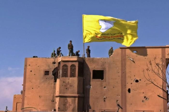 US-backed fighters of the Syrian Democratic Forces raise their flag in the Islamic State group's last redoubt of Baghouz as their commanders proclaim the total elimination of its "caliphate"