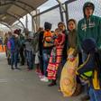 In this file photo taken on January 9, 2019 migrants from Cuba, Venezuela and Central America queue at the Paso del Norte International Bridge in Ciudad Juarez, Mexico, to cross the border and request political asylum in the United States