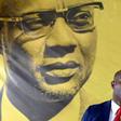 The founder of Guinea-Bissau's PAIGC party, Amilcar Cabral, looks down as spokesman Joao Bernardo Vieira speaks to the press