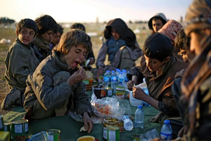 Yezidi boys share a meal in Syrian Democratic Forces-held territory after escaping the last scrap of the Islamic State group's collapsed "caliphate"
