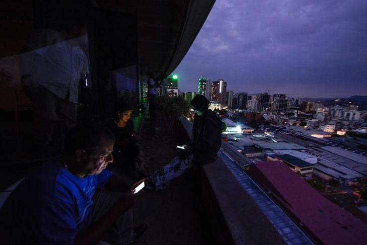 Journalists use cell phones during a huge blackout in Venezuela