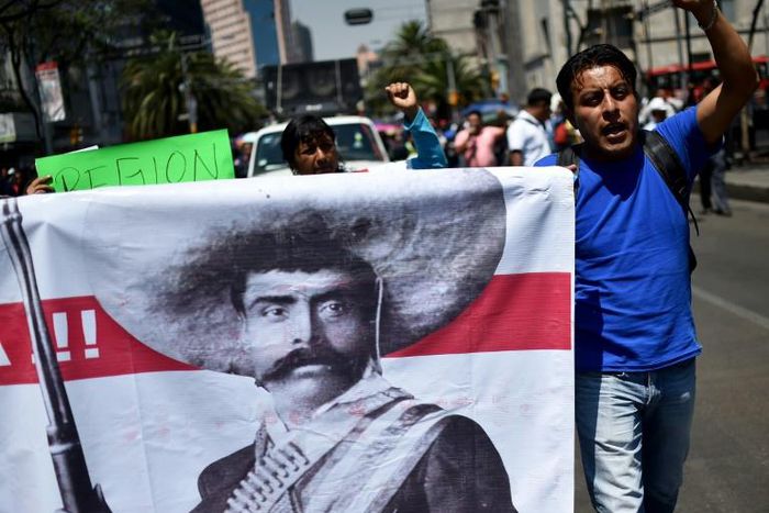 Teachers shout slogans carrying a banner depicting Mexican revolutionary leader Emiliano Zapata during a protest in Mexico City