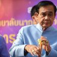 Thailand's Prime Minister Prayut Chan-O-Cha plays with a traditional flute as he arrives at the government house for a cabinet meeting on Tuesday, two days after the country's general election