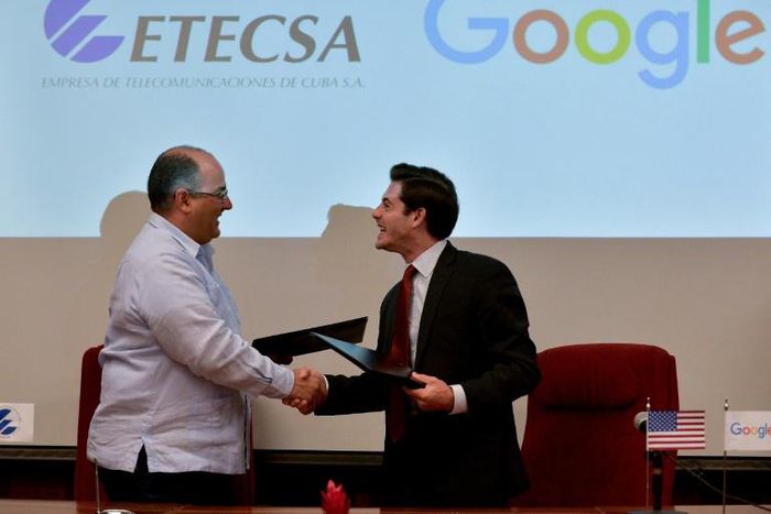 Cuban state-run Telecommunications Company ETECSA's investments vice-president, Luis Adolfo Iglesias Reyes (L), and the head of Google Cuba, Brett Perlmutter (R), shake hands after signing a memorandum of understanding at the Miramar Trade Center in Ha...
