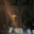 Smoke rises around the alter in front of the cross inside the Notre-Dame Cathedral in Paris as firefighters continued to extinguish the blaze on Tuesday