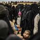 Women and children queue at a screening point after fleeing the Islamic State group's last redoubt in Syria