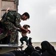 US-backed Syrian Democratic Forces help civilians at a screening area for those who are evacuated from the Islamic State group's embattled holdout of Baghouz, during an operation to expel IS jihadists from the area on February 26, 2019