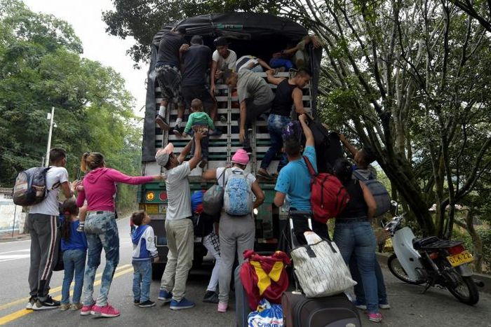 Venezuelan migrants (pictured February 2019) climb on a truck on the road from Cucuta to Pamplona in Colombia, which has received about a third of 3.7 million Venezuelan refugees
