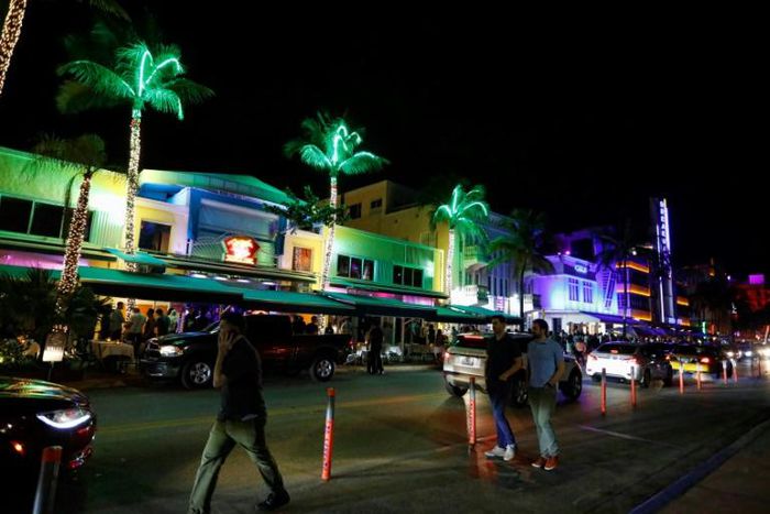 Tourists on Ocean Drive, where students on Spring Break drink bucket-sized discount cocktails