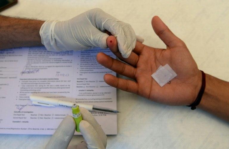 An Indian nurse carries out a test for HIV/AIDS: an unlicensed doctor is accused of infecting 46 people in one district
