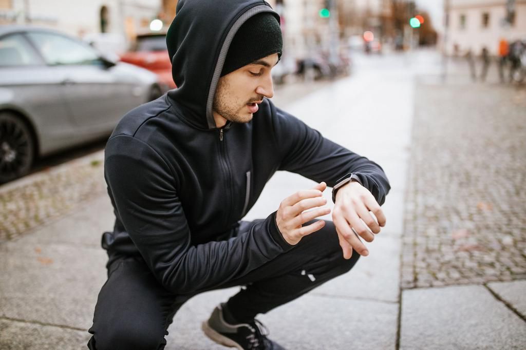 Male runner checking smartwatch heart rate monitor