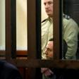 British citizen Jack Shepherd sits inside the defendants' cage during an extradiction hearing at a court in Tbilisi on March 26, 2019