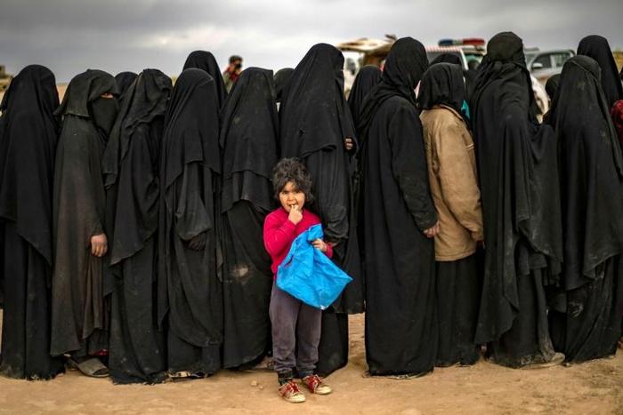 Women and children queue at a screening point after fleeing the Islamic State group's last Syrian stronghold
