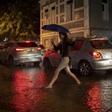 A woman crosses a street in Botafogo neighborhood in Rio de Janeiro, Brazil, as a downpour floods several areas of the city on April 8, 2019.