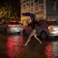 A woman crosses a street in Botafogo neighborhood in Rio de Janeiro, Brazil, as a downpour floods several areas of the city on April 8, 2019.