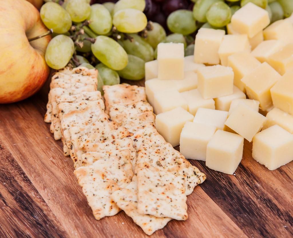High Angle View Of Cheese With Crackers And Fruits On Table