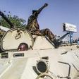 Sudanese protesters salute a military armoured vehicle at a demonstration in front of the army headquarters in Khartoum, as some ranks appear to be tiling towards the rallies