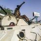 Sudanese protesters salute a military armoured vehicle at a demonstration in front of the army headquarters in Khartoum, as some ranks appear to be tiling towards the rallies