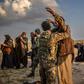 Men suspected of being Islamic State group fighters are searched after leaving the jihadists' last holdout of Baghouz in Syria