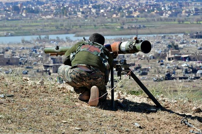 A fighter with the Syrian Democratic Forces (SDF) aims a recoiless gun toward a part of Baghouz where remaining Islamic State (IS) group fighters are holding out in their last position in the countryside of eastern Syria