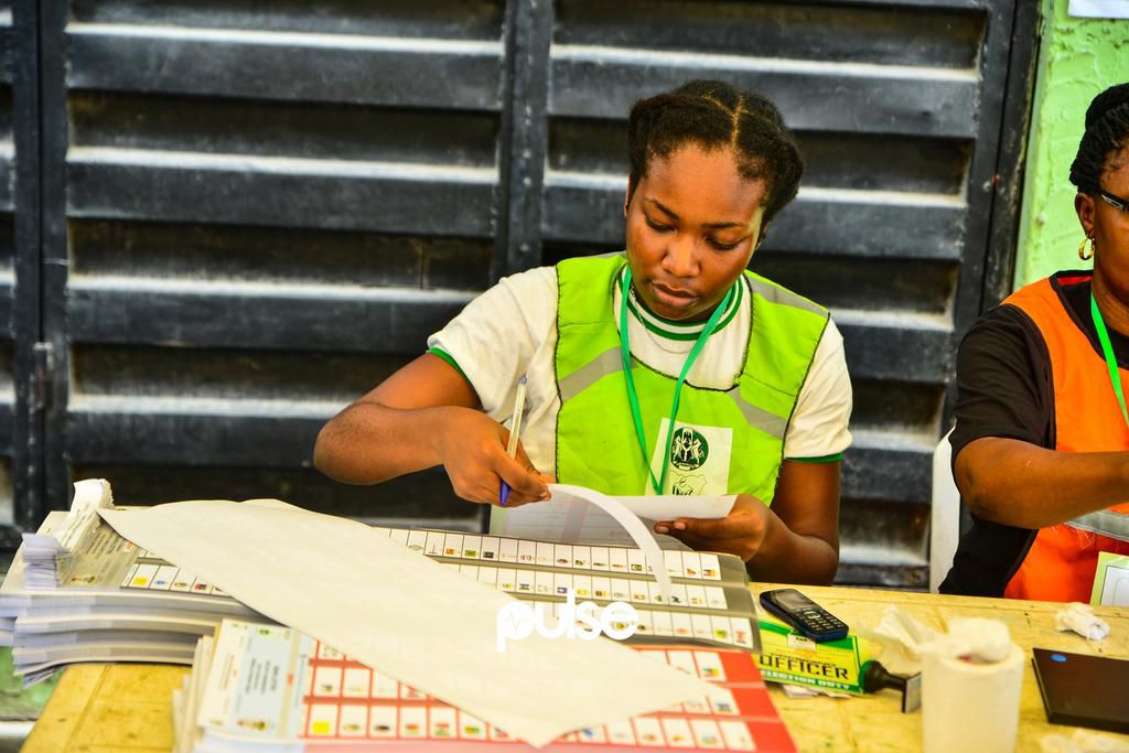 An NYSC member preparing ballot papers at a polling unit in Yaba (Pulse)