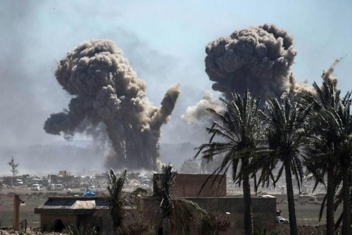 A plume of black smoke rises above the Islamic State group's last redoubt in the village of Baghouz in eastern Syria