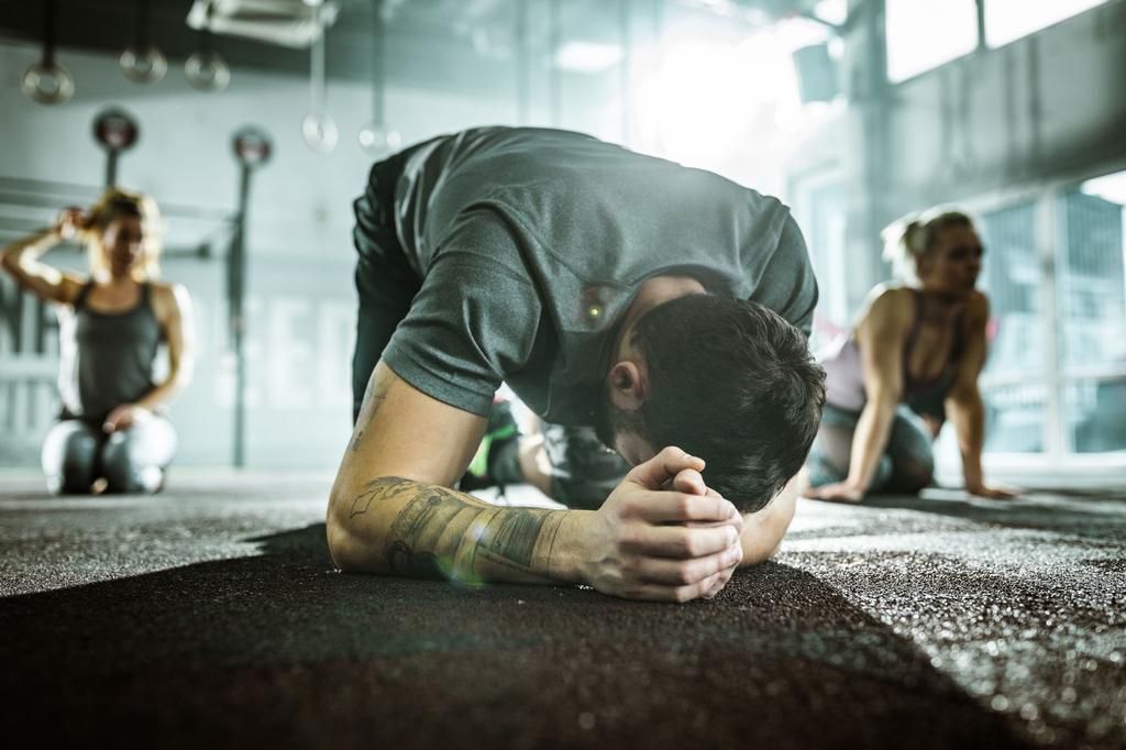 Exhausted male athlete after sports class in a gym.