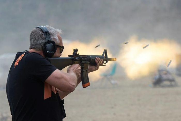 A man fires a machine gun on the main firing line during the Knob Creek Machine Gun Shoot