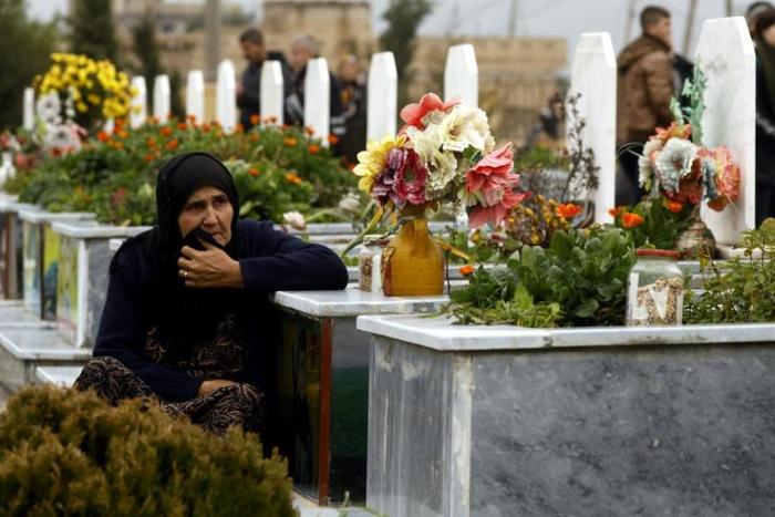 A woman in the northeastern Syrian town of Qamishli visits a grave during the February 2019 funeral of a fighter from the Kurdish-led YPJ. The Syrian Kurdish administration is seeking an international tribunal to try members of the Islamic State group