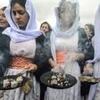 Members of the Yazidi minority take part in a ceremony during the exhumation of a mass grave of victims of the Islamic State group in northern Iraq