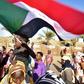 A young Sudanese boy waves a national flag as people celebrate concessions by Sudan's new military ruler, in Khartoum, on Saturday